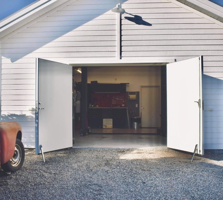 Välkommen in till Larssons Garage! Infarten till Larssons Garage med den stora garageporten helt öppen.